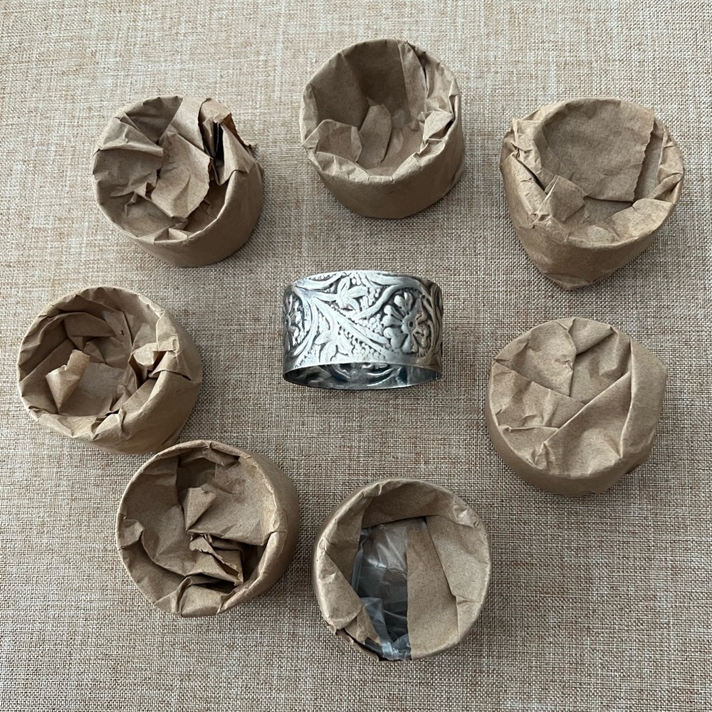 Set of (8) New Metal Embossed Silvertone floral pattern napkin rings 2“ x 1“.